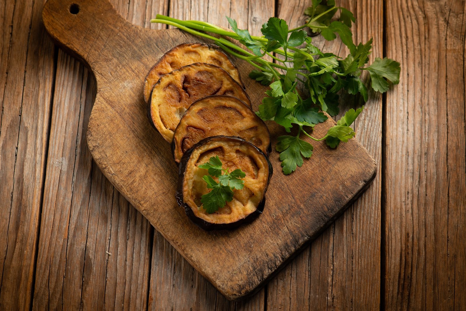 fried eggplants with parsley over cutting board